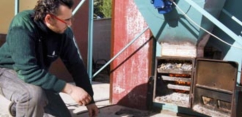 Un operario comprueba el funcionamiento de una caldera de biomasa en una instalación municipal de Coca