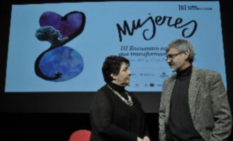 Clara Luquero y José Vicente Álvarez conversan bajo el cartel anunciador del encuentro. / Juan Martín