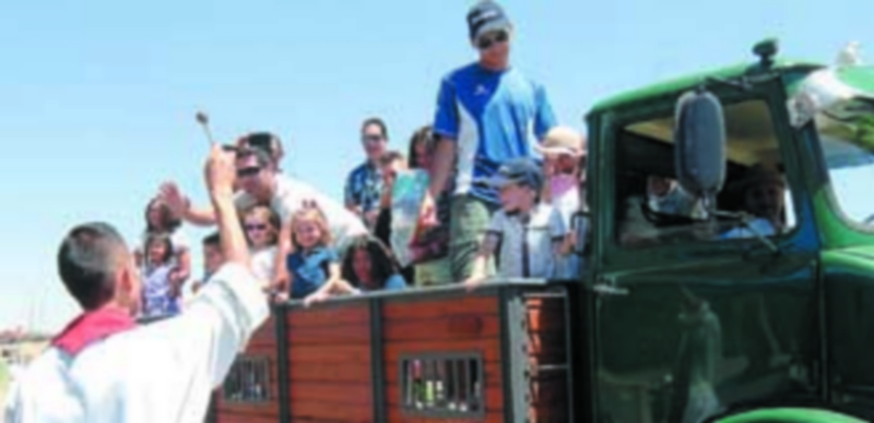 El párroco del Cristo del Mercado bendice uno de los camiones que desfilaron junto a la imagen del patrón San Cristóbal. / Elena Peña