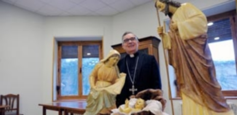El obispo de Segovia posa junto al nacimiento instalado en el comedor de la Casa de Espiritualidad