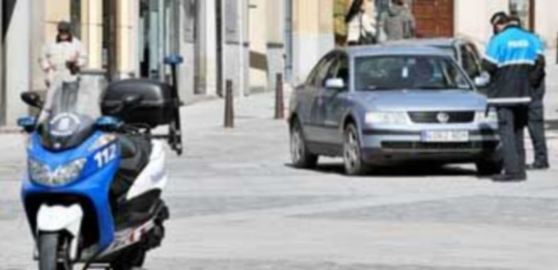Un agente de Policía Local impone la multa al conductor de un vehículo en el entorno de la Plaza Mayor. / Kamarero