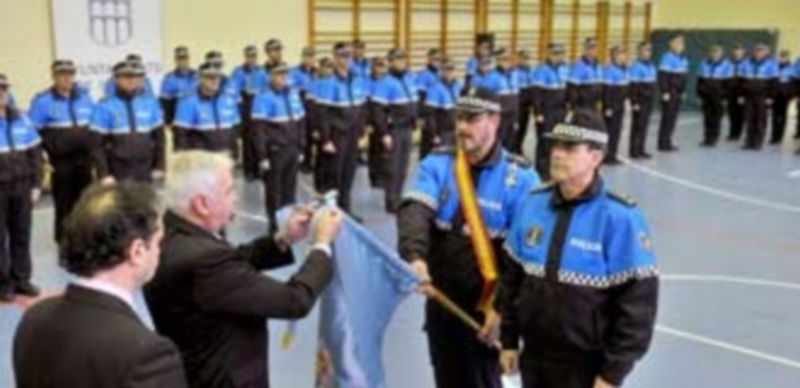 El presidente de la Hermandad de Donantes de Sangre coloca en el estandarte de la Policía el corbatín que les concedió en la última asamblea general. / Kamarero