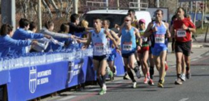 Un grupo de voluntarios ofrece botellas de agua a los atletas en la pasada Media Maratón. / Juan Martín
