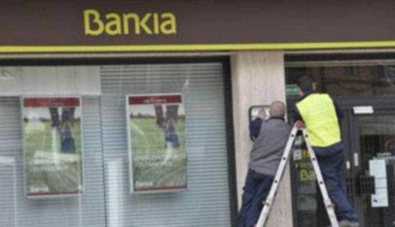 Imagen de archivo de dos operarios en el momento de adaptación de las oficinas a la imagen corporativa. / Juan Martín