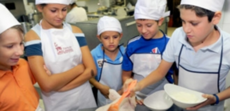 Los niños disfrutando y aprendiendo en un taller de cocina impartido por Cándido el verano pasado. / Kamarero
