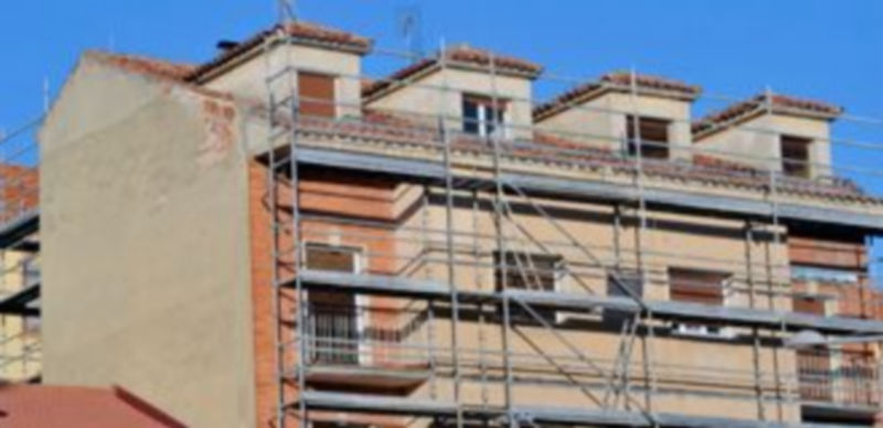 Los andamios sobresalían ayer en una vivienda en rehabilitación situada en la plaza de Somorrostro de la capital segoviana. La rehabilitación es una de las salidas para el sector. / Kamarero