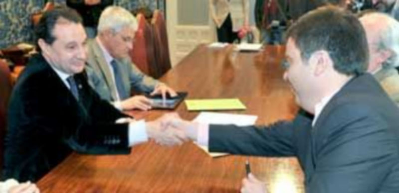 Arahuetes y Yagüe estrechan la mano tras firmar el acuerdo en presencia del gerente de Evisego
