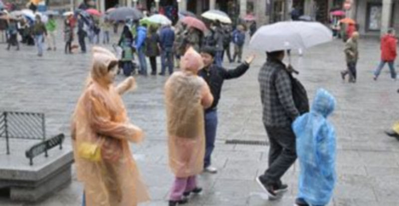 Los segovianos y visitantes recurrieron ayer a los chubasqueros y paraguas para salir a la calle. / Juan Martín