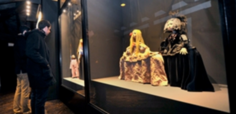 Dos visitantes contemplan una de las vitrinas que contienen marionetas de Francisco Peralta. / Kamarero