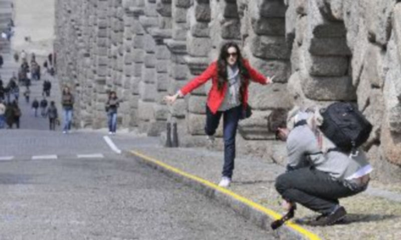 Una pareja de turistas se prepara para tomar una fotografía con el Acueducto. / Juan Martín
