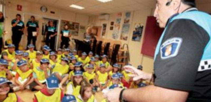 Un grupo de niños escucha con atención las indicaciones de un Policía Local con motivo de la semana de la movilidad. / L. M.