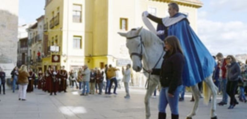 Uno de los heraldos a caballo da lectura al anuncio del pregón en la Calle Real