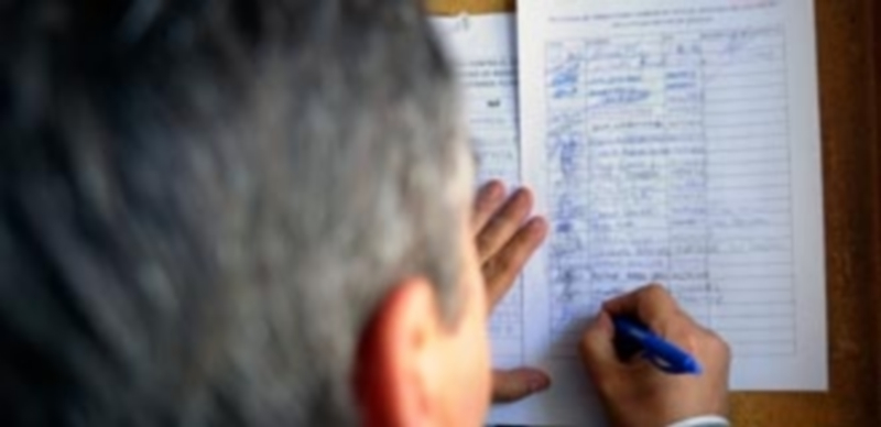 Un cliente firma el escrito de solicitud en un establecimiento de hostelería de la Plaza Mayor. / Kamarero