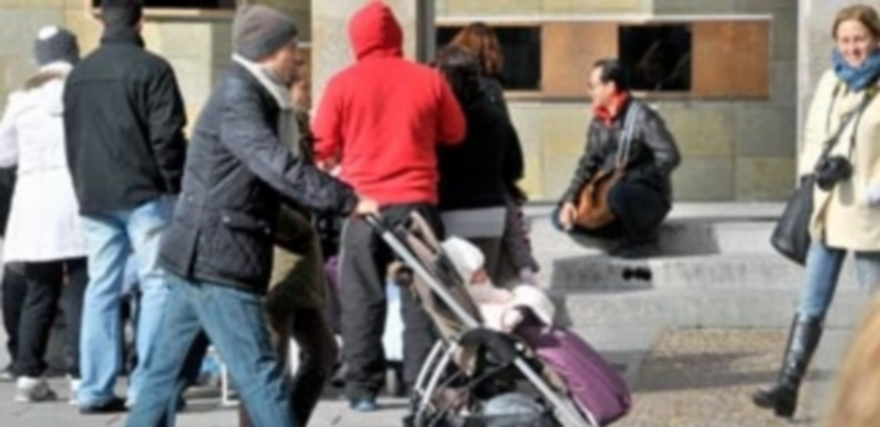 Un padre empuja el cochecito de un niño