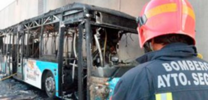 Un bombero observa el estado en que quedó el autobús tras sufrir el incendio. / Javier López-Alarma