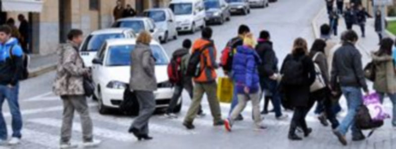 Un grupo de peatones cruza por un paso señalalizado al inicio de la subida de la calle San Juan