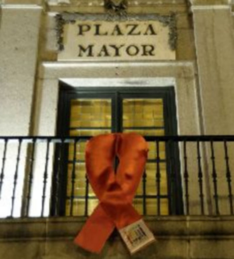 Segoentiende colocó ayer el lazo rojo que identifica la lucha contra el Sida en el balcón principal del Ayuntamiento de Segovia. / Juan Martin