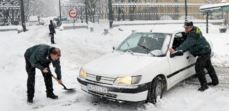 Dos agentes de la Guardia Civil intentan retirar un vehículo que se había quedado cruzado a la entrada del Real Sitio. / Kamarero