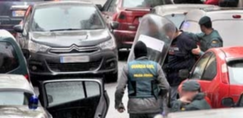 Momento en que los guardias civiles proceden al traslado de uno de los hombres detenidos ayer en su domicilio. / Kamarero