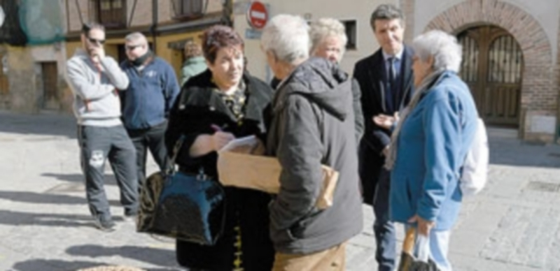 La alcaldesa toma nota en su libreta de las sugerencias que realiza uno de los vecinos del barrio. / TAMARA DE SANTOS