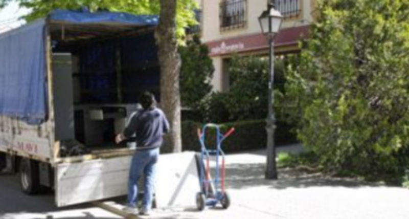 Un operario carga material procedente de la oficina de Caja Segovia que dejará de funcionar mañana viernes. / Juan Martín