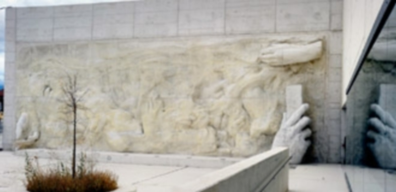 En la plaza de acceso se ha incorporado un mural en altorrelieve de hormigón blanco que representa las manos como símbolo de creación. / Kamarero