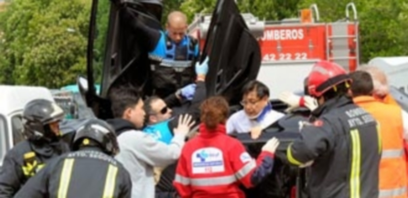 Bomberos y personal sanitario ayudan a salir del vehículo volcado a uno de los ocupantes. / KAMARERO