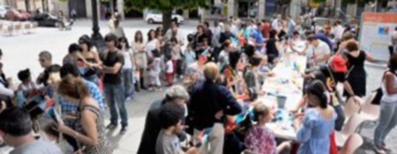 Cientos de personas se afanaron durante la mañana de ayer en la Plaza Mayor para elaborar los molinillos con los colores de Segovia 2016. / Kamarero