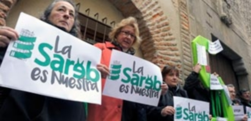 Los  representantes de la PAH mostraron carteles alusivos a su demanda. / Kamarero