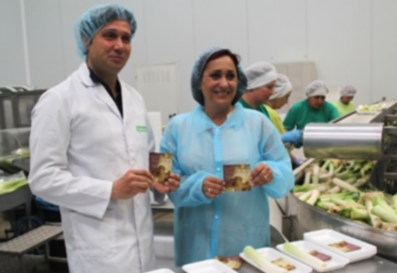 Bernardo Tabuenca y la concejala incluyendo folletos en las hortalizas. / C. N.