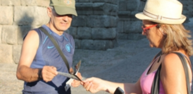 Un repartidor de publicidad entrega un ‘flyer’ a una turista. / Fran Muñoz