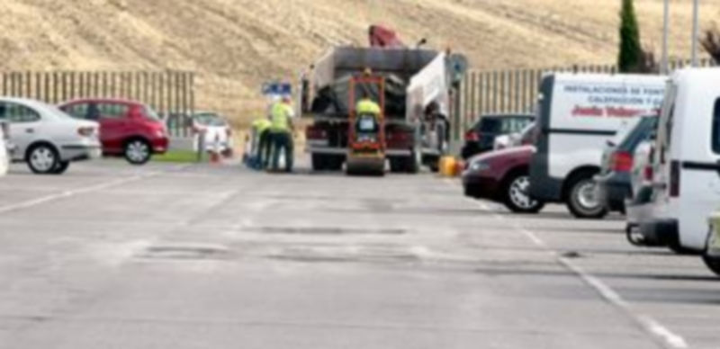 Trabajos de bacheo en la calle exterior del aparcamiento del complejo hospitalario. / Juan Martin