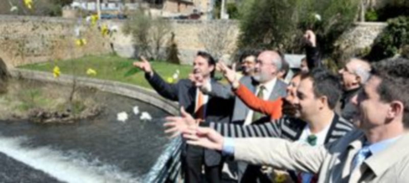 Autoridades y representantes del pueblo gitano en Segovia arrojan flores al Eresma con el deseo de paz./ KAMARERO