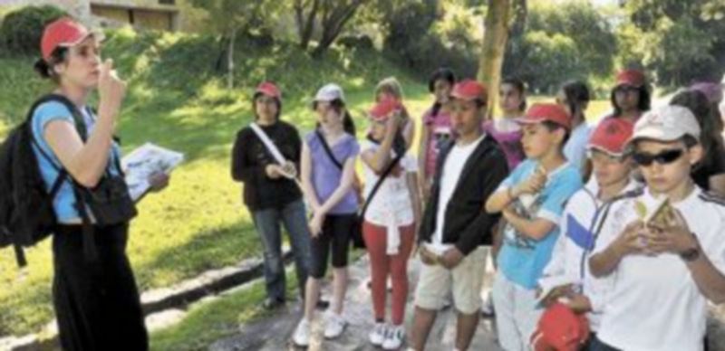 Un grupo de escolares atiende las explicaciones de una monitora