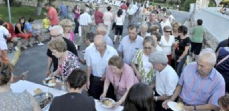 Un grupo de personas disfrutan de la comida ofrecida por la residencia de ancianos del barrio de San Lorenzo en la pasada edición de las fiestas de 2011. / Kamarero
