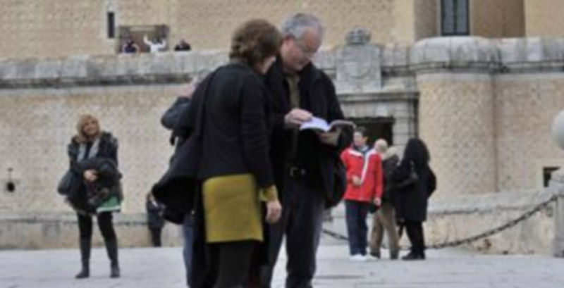 Dos turistas consultan una guía de la ciudad frente al Alcázar de Segovia. / Kamarero