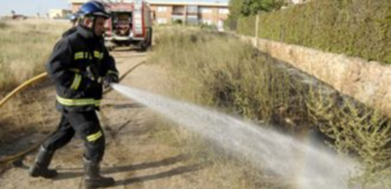 Un bombero apaga el fuego en Las Lastras. / Alberto Benavente