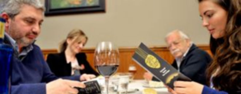 Una pareja se interesa por el menú de Titirimundi con los productos Tierra de Sabor que hasta el próximo 16 de mayo ofrecen 33 restaurantes. / Kamarero