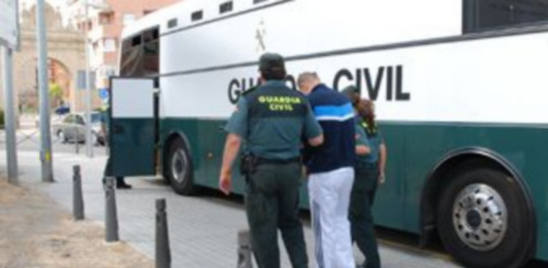 Uno de los presuntos integrantes de la organización es conducido por los agentes al interior del vehículo en el que se trasladó a los detenidos. / El Adelantado