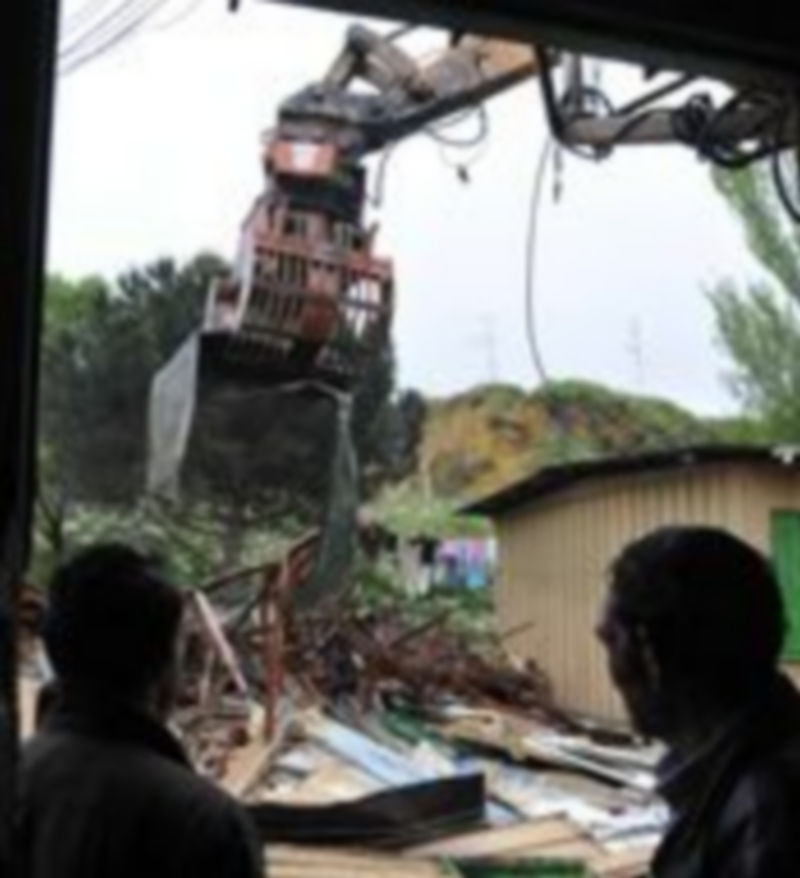 Dos vecinos del poblado del Tejerín observan la demolición del mismo. / J. Martín