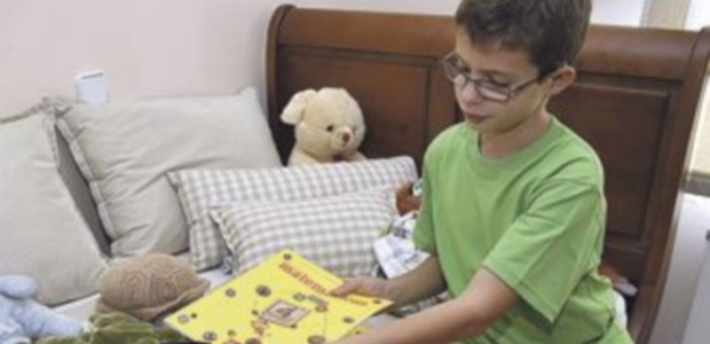 Un escolar preparando la mochila con los libros y el material que utiliza en clase. / Alberto Benavente