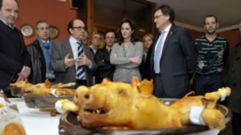 José María Ruiz explica a la consejera Silvia Clemente las características del cochinillo en sus distintas variedades al consumidor. / Juan Martín.