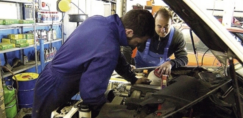 Los talleres resaltan la importancia de vigilar el mantenimiento del coche 1 Dos mecánicos de un taller segoviano revisan el motor de un vehículo. / Juan Martin