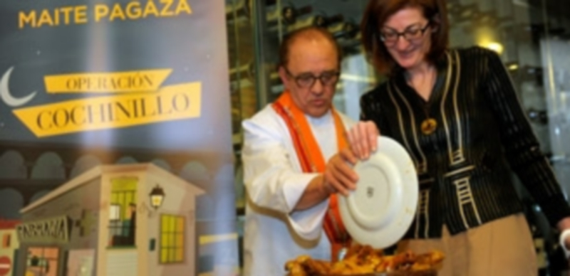 José María Ruiz instruyó a la escritora y política vasca en la ceremonia de trinchar el cochinillo con el plato. / Kamarero