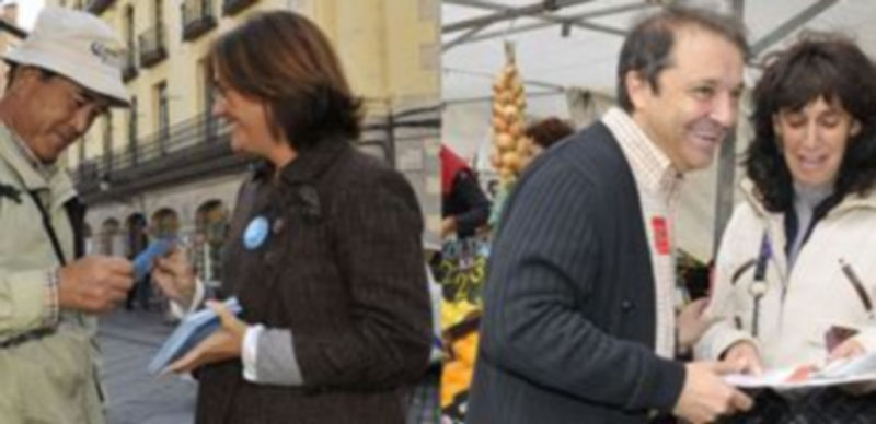 Beatriz Escudero entrega propaganda electoral a un turista japonés y Juan Luis Gordo sonríe divertido junto a una ciudadana en el mercado de los Jueves. / J.Martín.