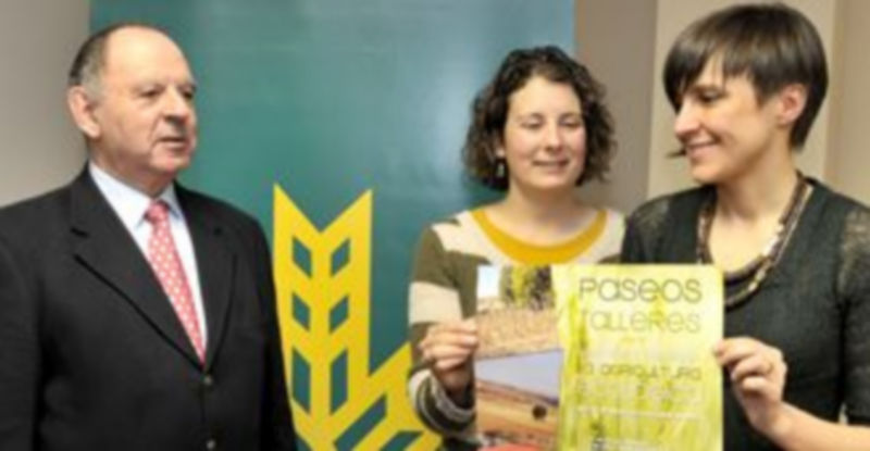 Marta García y Beatriz Serrano muestran el cartel anunciador de las rutas./ Alberto Benavente