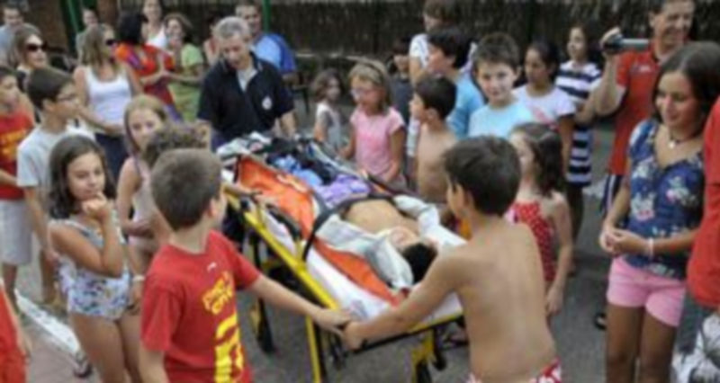 Un sanitario traslada a una de las supuestas víctimas inmovilzada en camilla durante el simulacro. / Juan Martín