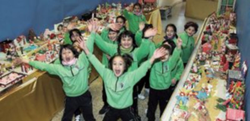 Un grupo de niños del Claret posan junto al belén