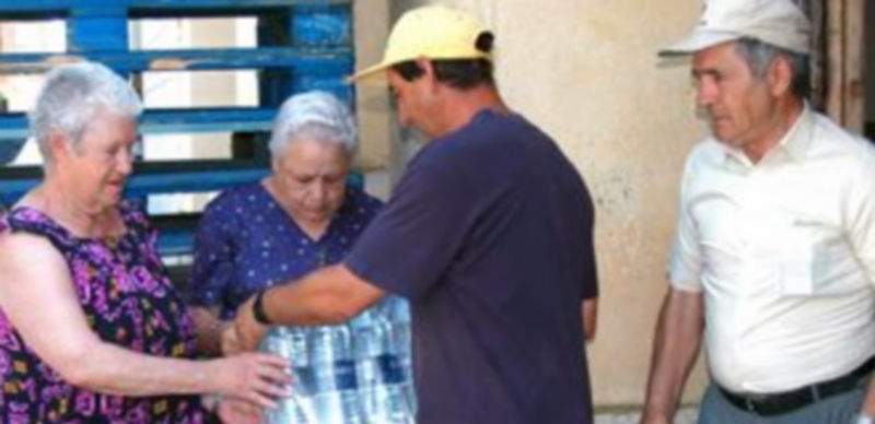Vecinos de Pinarejos reciben agua embotellada para uso doméstico en esta imagen de archivo. / Guillermo Herrero.