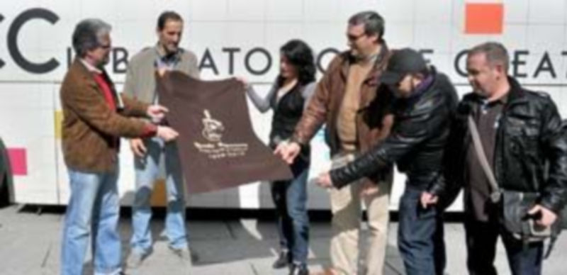 Los miembros de la Ronda entregan a la organización de “La Noche de Luna Llena” el trozo de paño que integrará la gran alfombra. / Kamarero